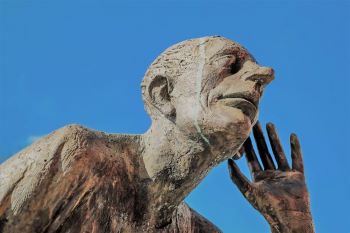 Statue of person listening with hand to ear