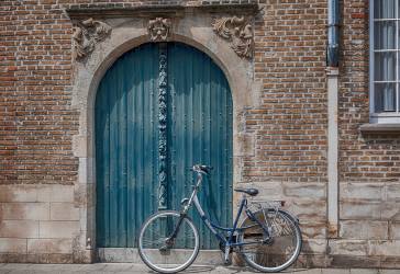 Large door in brick wall with bicycle in front